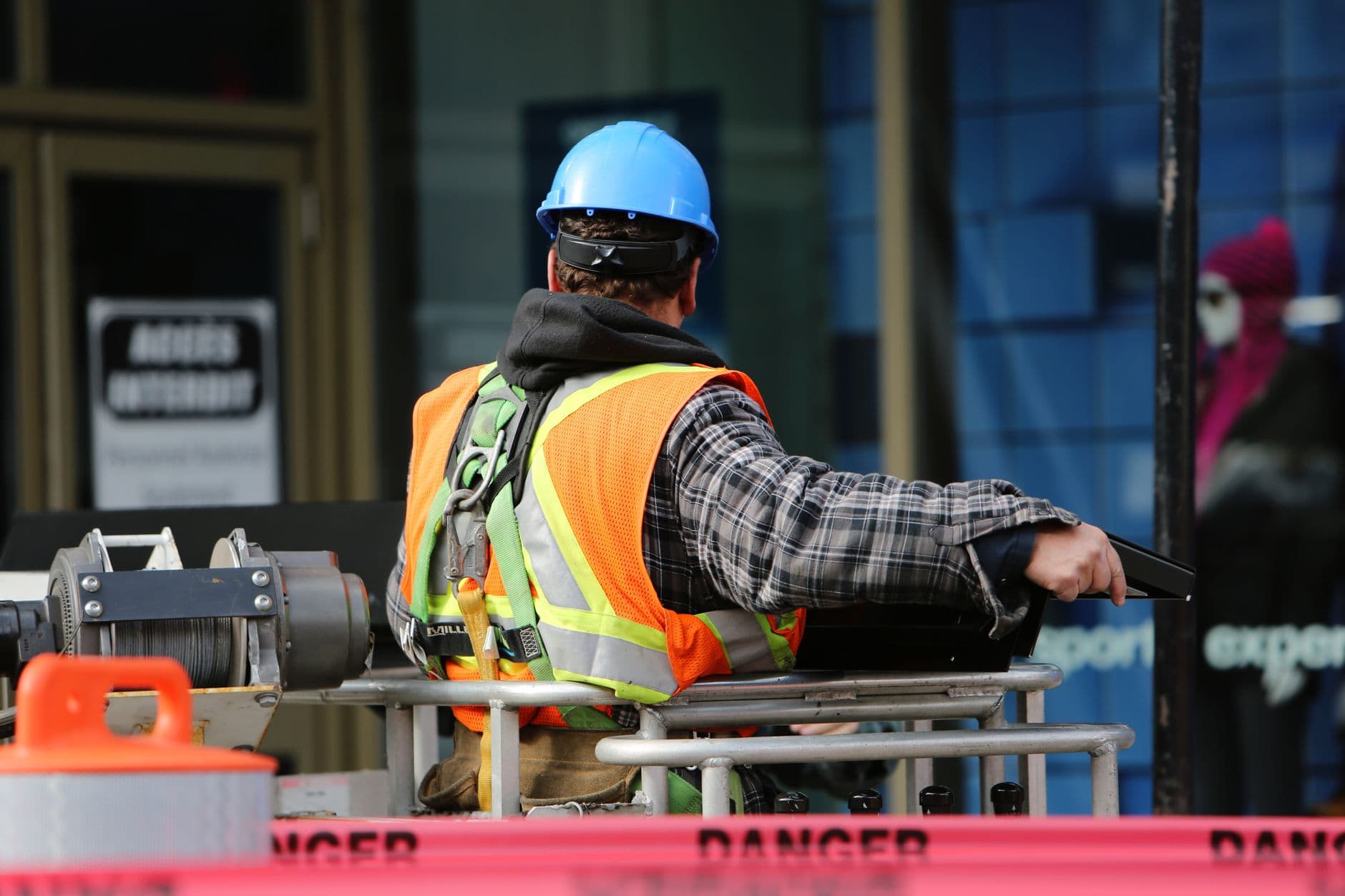 Handwerker in Arbeitskleidung auf einer Hebebühne an einer Gebäudefassade